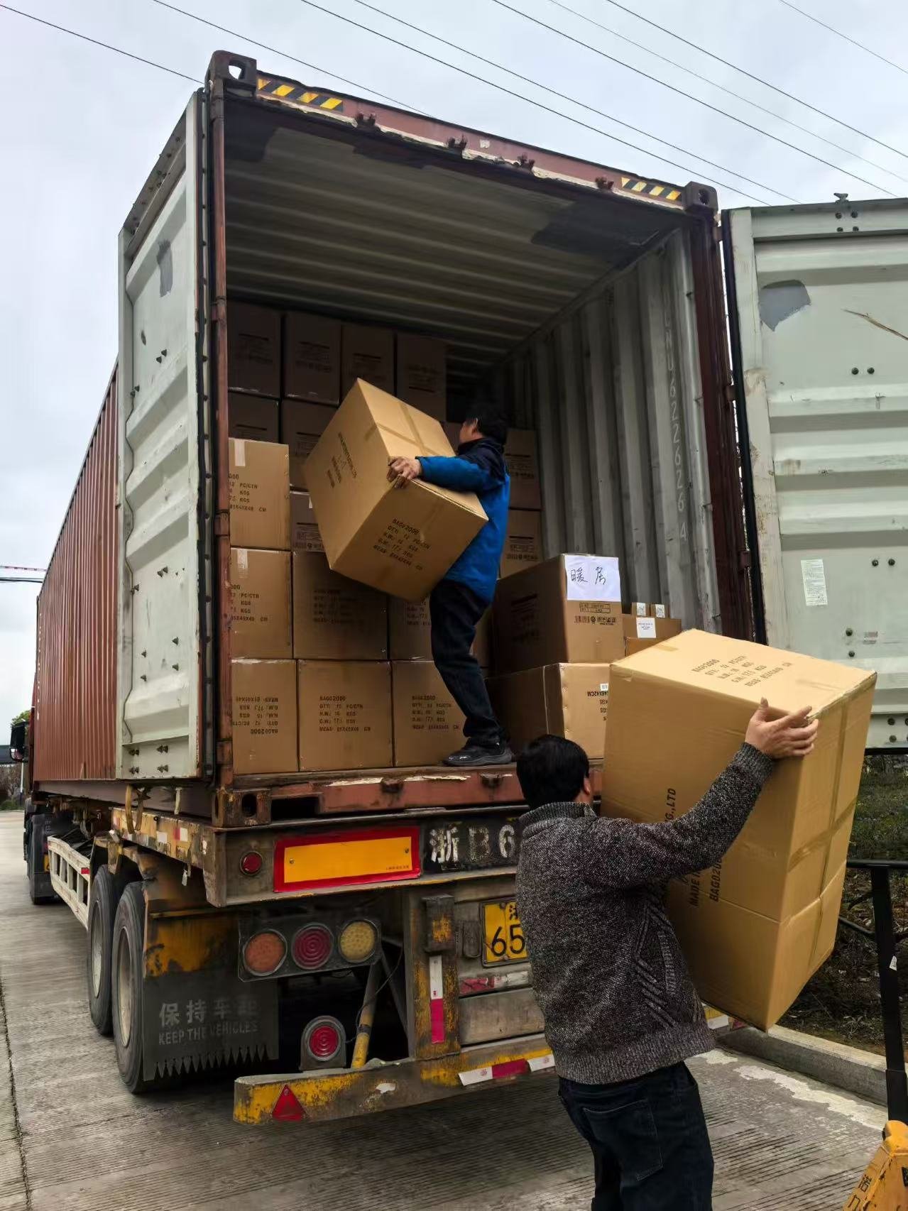 Workers loading cartons into a container